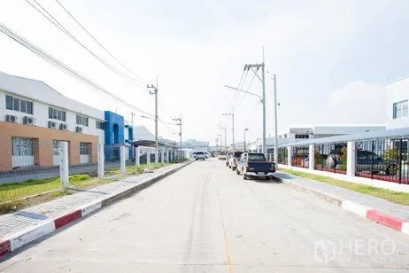 Factory for rent in Chachoengsao - Wide internal road of the industrial estate with utilities and parked vehicles.