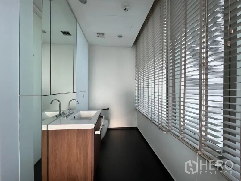 คอนโด ให้เช่าหรือขายในPathum Wan, Bangkok - ห้องน้ำอีกห้องพร้อมอ่างล้างหน้าคู่ เคาน์เตอร์ยาว กระจกเต็มผนัง และมู่ลี่หน้าต่าง