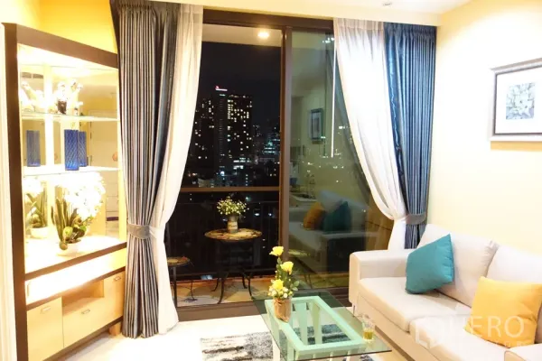 คอนโด ให้เช่าในKhlong Toei, Bangkok - ห้องนั่งเล่นสว่างพร้อมโต๊ะกระจก โซฟา และระเบียงชมวิวเมืองยามค่ำในคลองเตย