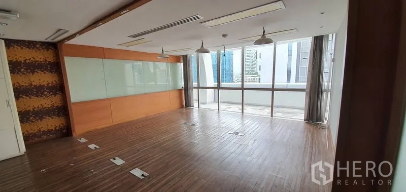 Office Space for rent in Watthana, Bangkok - Glass-lined meeting room with pendant lights, a whiteboard wall, and wooden flooring.