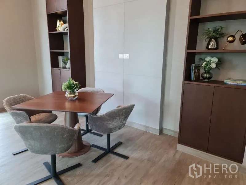 Condominium for sale in Yan Nawa, Bangkok - Contemporary dining nook with wooden table, four upholstered chairs and built-in shelving.