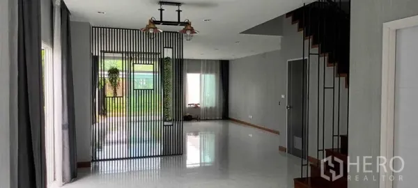 联排别墅 出租或出售在Saphan Sung, Bangkok - 一层宽敞客餐厅，落地窗面向花园景观。