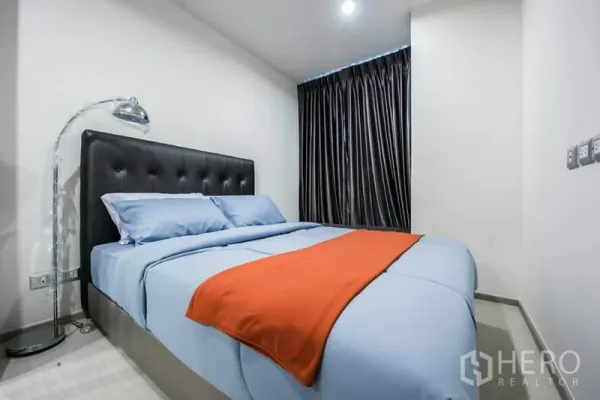 คอนโด ให้เช่าในKhlong Toei, Bangkok - ห้องนอนอบอุ่น เตียงหัวเตียงบุสีดำ ผ้าปูสีน้ำเงิน ผ้าม่านทึบ