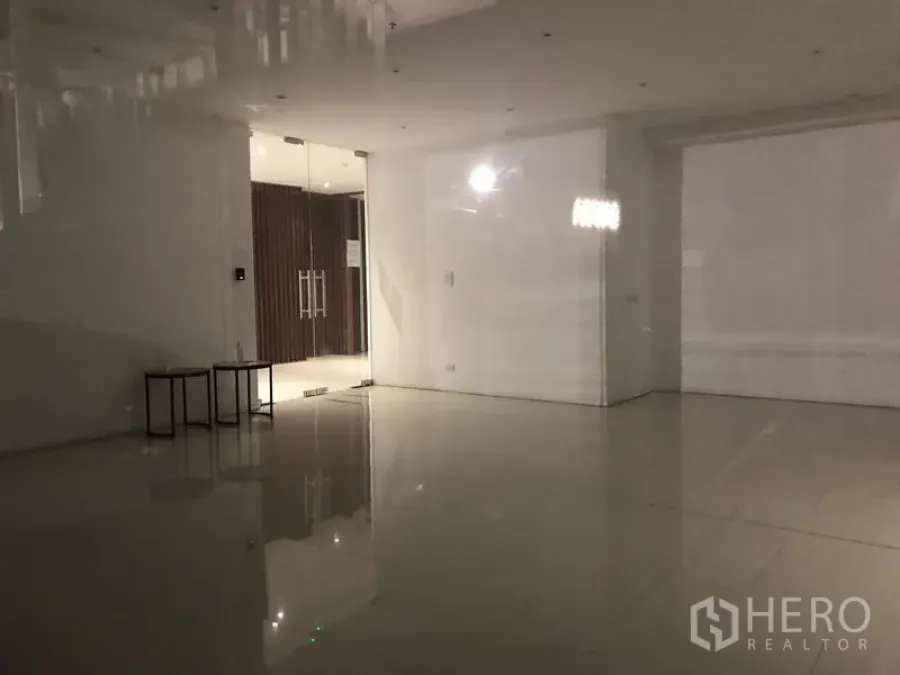 零售空间 出租在Khlong Toei, Bangkok - 开放式室内空间，亮面地砖、筒灯与玻璃入口。