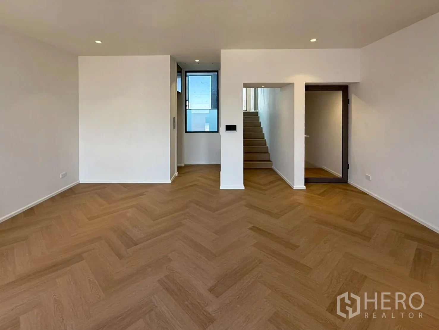 家庭办公室 for rent or sale in Watthana, Bangkok - 室内开阔空间，人字形木地板与楼梯。