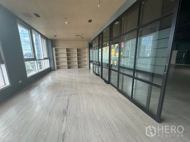 Office Space for rent in Bang Rak, Bangkok - Bright meeting or project room with shelving and wide windows over the Bangkok skyline.