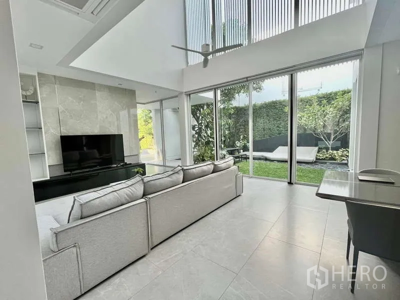 独立式住宅 出租或出售在Bang Phli, Samut Prakan - 客餐厅一体，滑动落地门直通草坪花园。