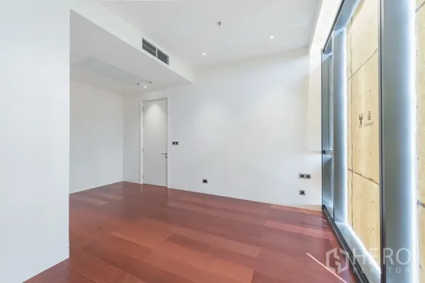 คอนโด ขายในWatthana, Bangkok - ห้องนอนมุมห้องมีไฟดาวน์ไลท์ ระบบแอร์แบบฝังฝ้า และกระจกสูงจรดเพดานเหนือพื้นไม้