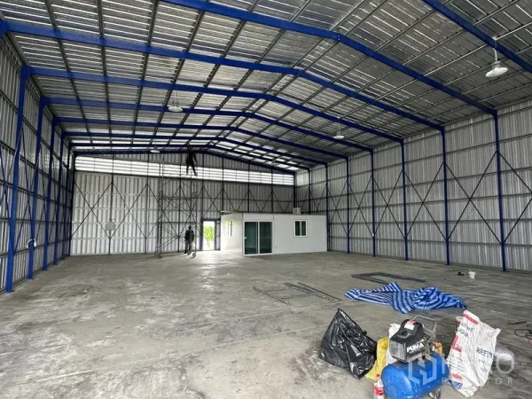 货栈 出租在Khlong Luang, Pathum Thani - 钢结构屋架与通风百叶，室内为平整混凝土地面。