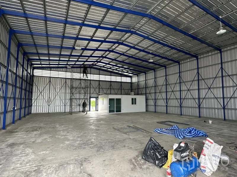 货栈 出租在Khlong Luang, Pathum Thani - 钢结构屋架与通风百叶，室内为平整混凝土地面。