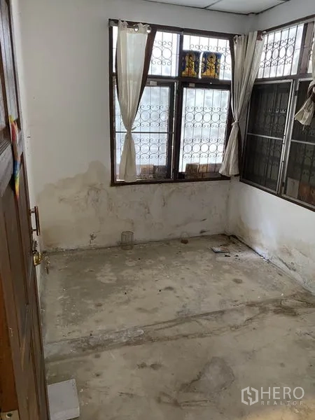 联排别墅 出租在Lat Phrao, Bangkok - 楼上卧室，水泥地面与转角窗，适合改造