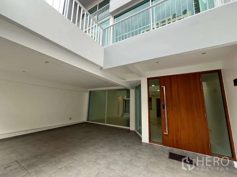 带办公室的家 出租在Khlong Toei, Bangkok - 一层入口小庭院，木质大门与整面推拉玻璃墙。