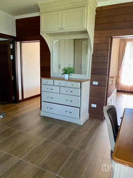 Detached House for sale in Bang Bo, Samut Prakan - Bedroom area with built-in white dresser, wood-paneled wall, and desk.