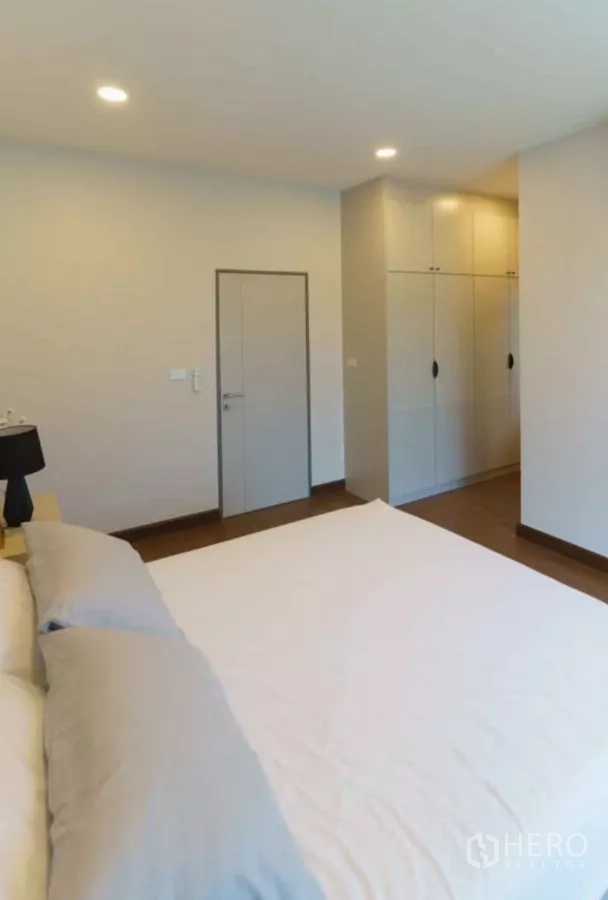 Detached House for rent or sale in Bang Phli, Samut Prakan - Bedroom corner with closets and door on wood flooring.