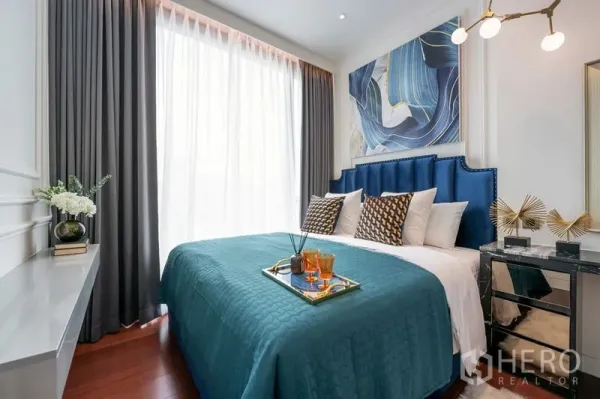 คอนโด ให้เช่าในWatthana, Bangkok - ห้องนอนอบอุ่น หน้าต่างบานใหญ่ หัวเตียงบุผ้าโทนสีน้ำเงิน พร้อมผ้าคลุมเตียงสีเทอควอยซ์