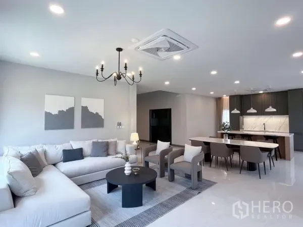 Detached House for rent or sale in Bang Phli, Samut Prakan - Bright open-plan living, dining and kitchen with chandelier, island counter and recessed lighting.