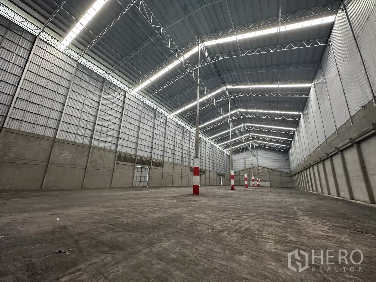 货栈 出租在Mueang Pathum Thani, Pathum Thani - 高挑仓库内部，钢桁架屋顶与条形天窗照明，空间开阔。