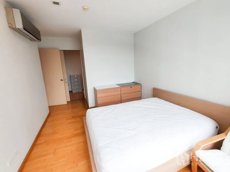 คอนโด ให้เช่าในKhlong Toei, Bangkok - ห้องนอนที่สองมีเตียงคู่ ตู้ลิ้นชัก และเครื่องปรับอากาศบนพื้นไม้โทนอุ่น