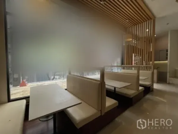 零售空间 出租在Khlong Toei, Bangkok - 临窗卡座、木格栅天花与磨砂玻璃门面。