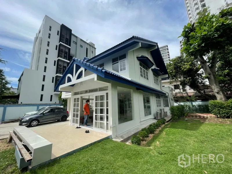 บ้าน ให้เช่าในKhlong Toei, Bangkok - บ้านเดี่ยวสองชั้นหลังคาสีฟ้า กระจกบานใหญ่ พร้อมชานหน้าบ้านและสนามหญ้าเขียว คลองเตย