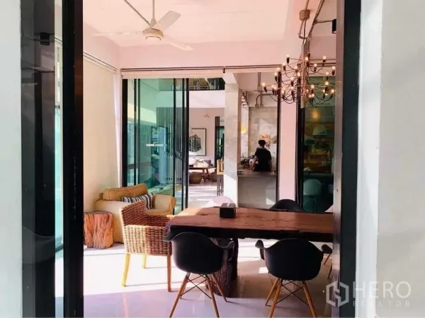 带办公室的家 出售在Wang Thonglang, Bangkok - 采光充足的开放式办公/餐区，原木长桌、藤椅与吊灯，配滑动玻璃门