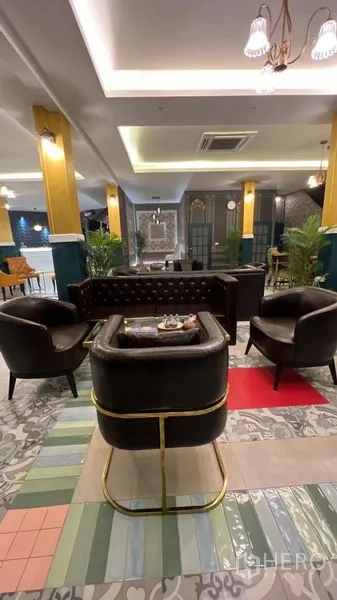 พื้นที่ขายปลีก ให้เช่าในKhlong Toei, Bangkok - มุมนั่งเล่นเก้าอี้หนังสีดำ รายละเอียดทอง และพื้นกระเบื้องลายสีสัน