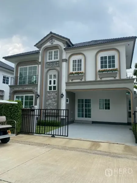 Detached House for rent in Bang Phli, Samut Prakan - Two-storey detached house with gated driveway, balcony and stone-accent facade.