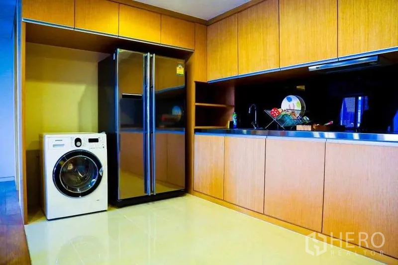 คอนโด ให้เช่าในWatthana, Bangkok - ครัวโมเดิร์น ท็อปสแตนเลส แผงกันเปื้อนสีดำ ตู้เย็นสองประตู และเครื่องซักผ้าฝาหน้า