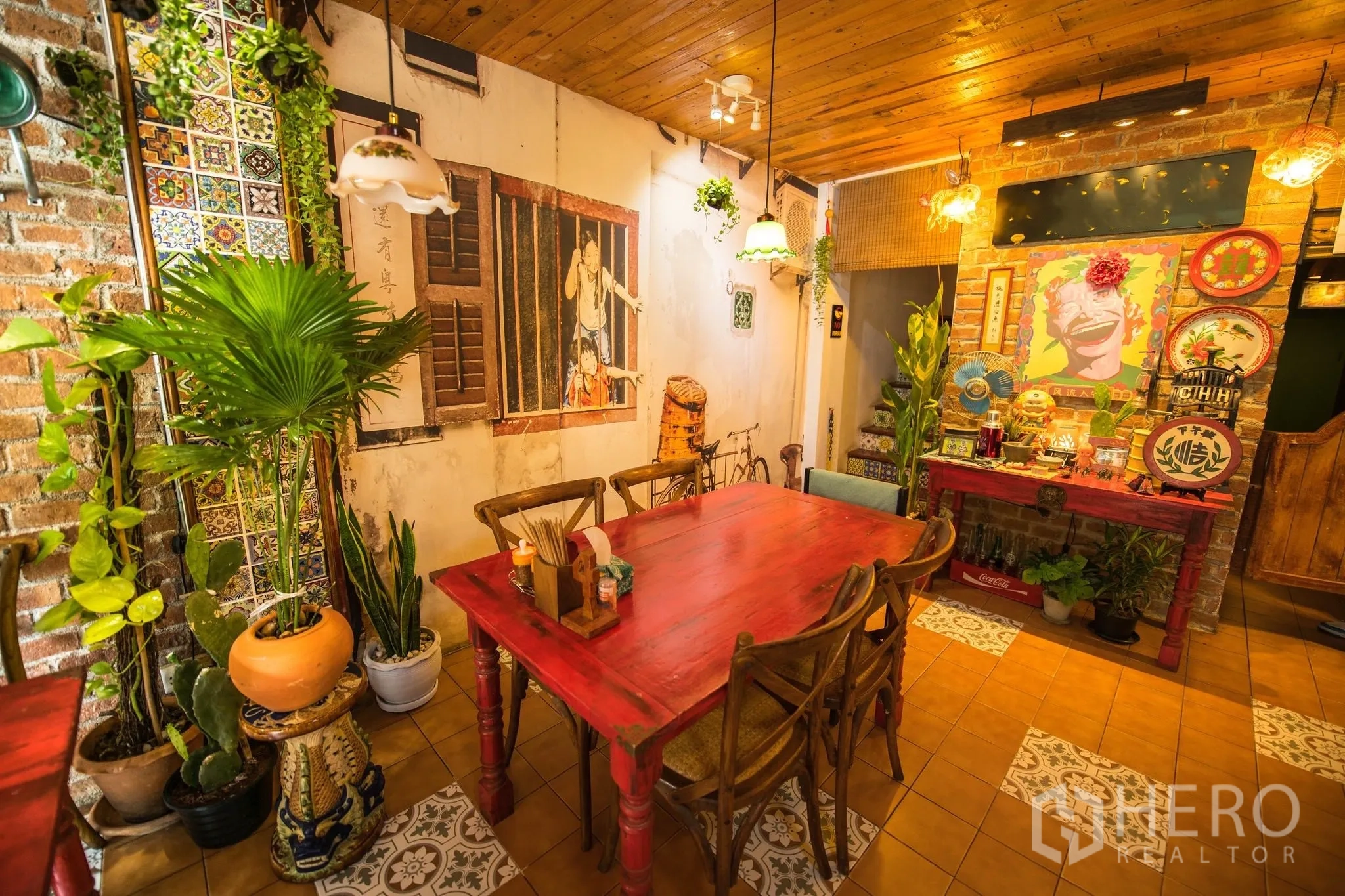 零售空间 for rent in Watthana, Bangkok - 红色餐桌旁的绿植、花纹地砖与墙面壁画的咖啡馆内景。