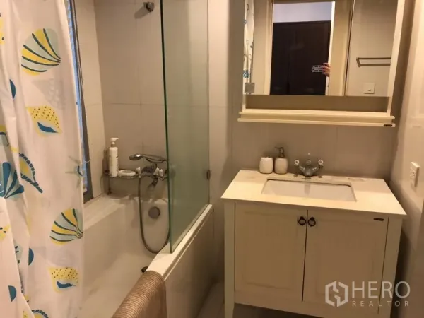 คอนโด ให้เช่าในPathum Wan, Bangkok - ห้องน้ำพร้อมอ่างอาบน้ำกั้นกระจก เคาน์เตอร์อ่างล้างหน้าสีขาวและตู้กระจก