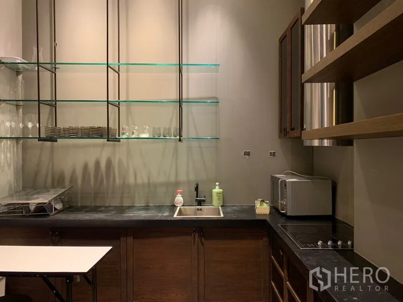 Condominium for rent - Compact pantry kitchen with glass shelves, sink, cooktop and microwave.