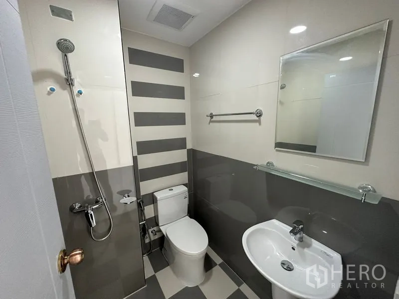 Home Office for rent or sale - Modern bathroom with walk-in shower, toilet, vanity and striped wall tiles.