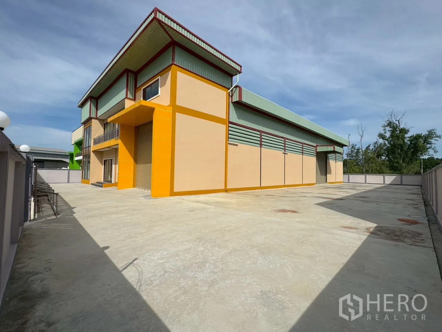 工厂 for sale in Mueang Samut Sakhon, Samut Sakhon - 工厂侧面可见环绕建筑的宽阔混凝土场地与装卸区。