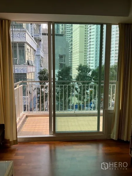 คอนโด ให้เช่าในKhlong Toei, Bangkok - ประตูกระจกบานเลื่อนออกสู่ระเบียง มองเห็นต้นไม้และอาคารรอบข้าง