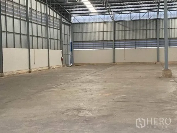Warehouse for rent in Lat Krabang, Bangkok - Open-plan warehouse bay with metal cladding, skylight panels and a wide loading door.