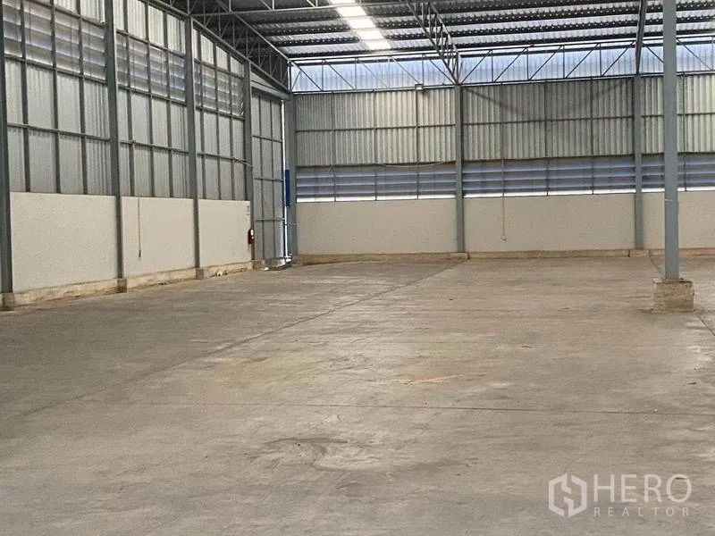 Warehouse for rent in Lat Krabang, Bangkok - Open-plan warehouse bay with metal cladding, skylight panels and a wide loading door.