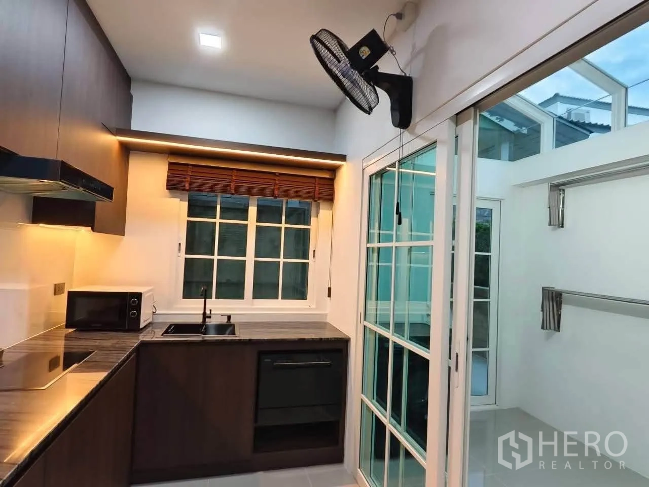 Detached House for rent in Bang Phli, Samut Prakan - Fitted kitchen with hob, oven and sliding door to the utility area.