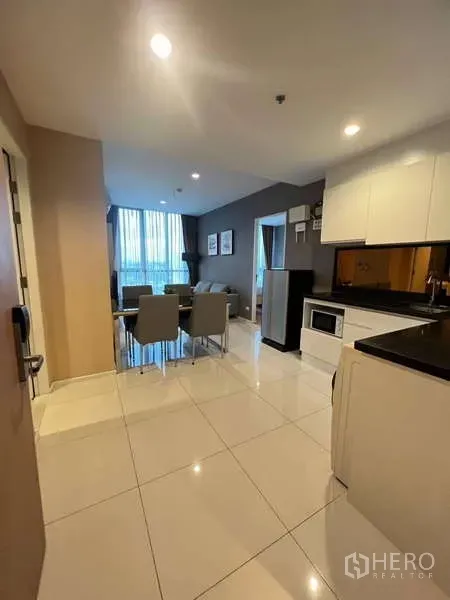 Condominium for rent - Entryway view toward the kitchen and lounge, showing tiled floors and abundant natural light.