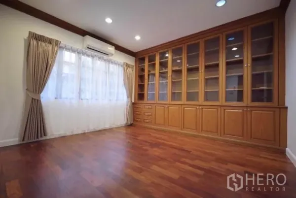 独立式住宅 出租在Bang Phli, Samut Prakan - 书房，整面墙木质柜体与空调。