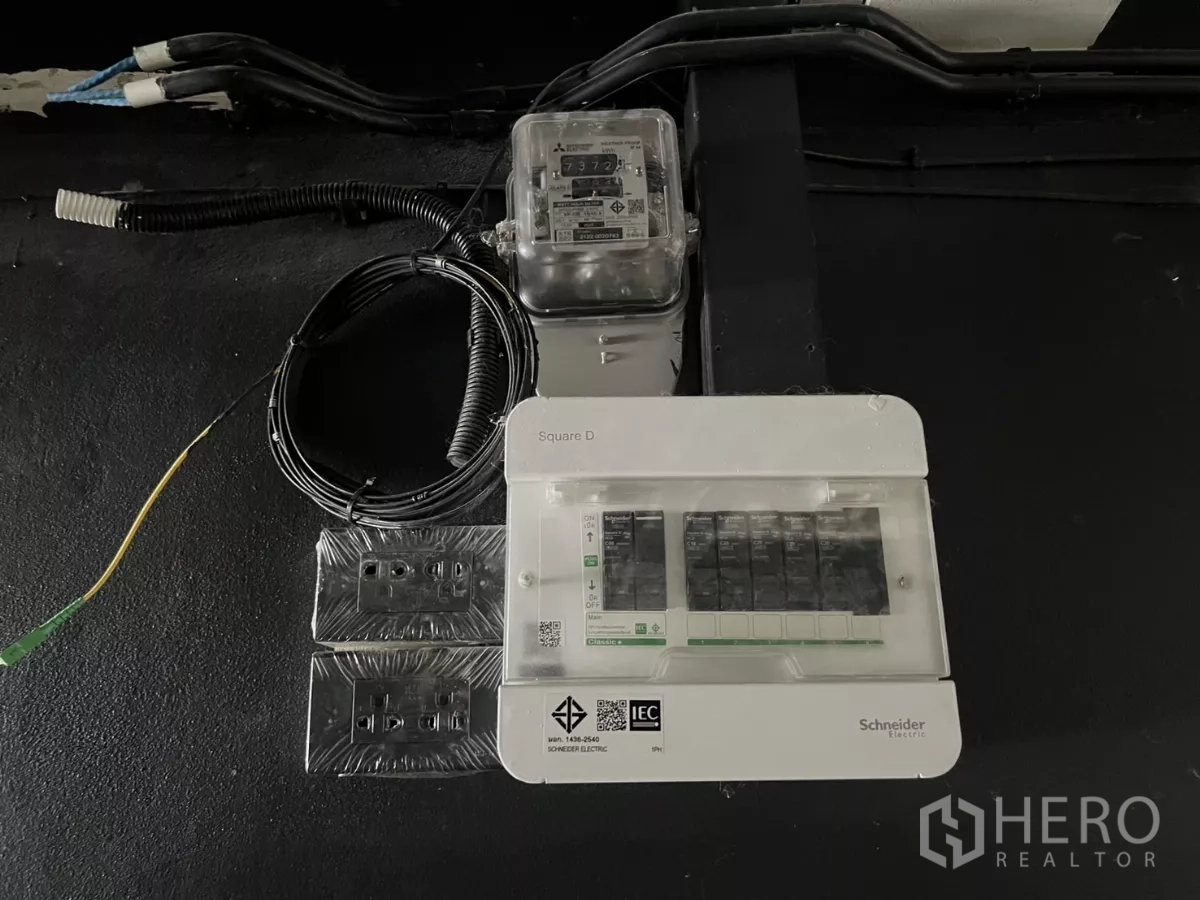 零售空间 出租在Watthana, Bangkok - 电表与断路器配电箱特写，黑色墙面。