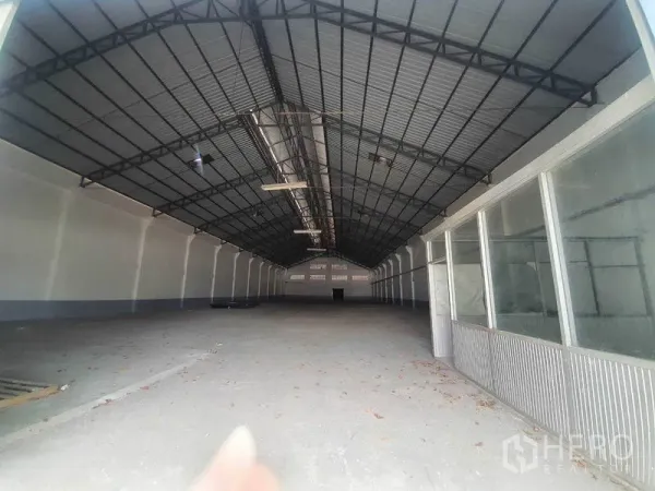 货栈 出租在Nakhon Pathom - 仓库内部空间开阔，高挑钢结构屋顶、无柱大跨度地面。