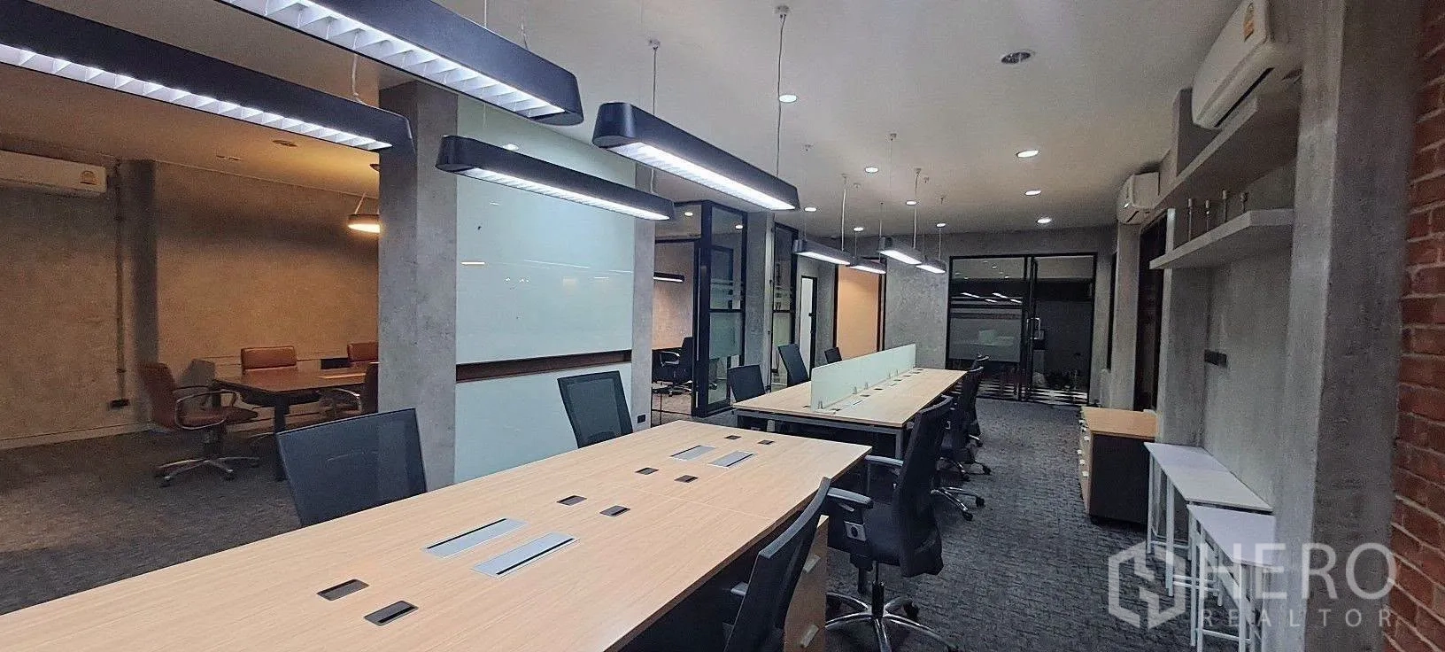 家庭办公室 for rent in Lat Phrao, Bangkok - 开放式长桌工位，红砖墙装饰与线性吊灯。