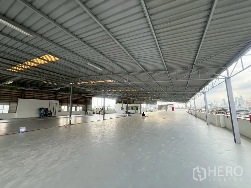 展厅 出租在Khlong Toei, Bangkok - 屋顶覆盖钢结构雨棚的开放区域，可远眺城市天际线。