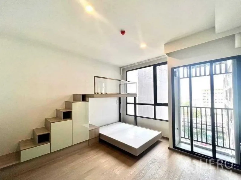 Condominium for sale - Bright bedroom with platform bed, storage stairs and glass-railed shelf beside large windows and a balcony.