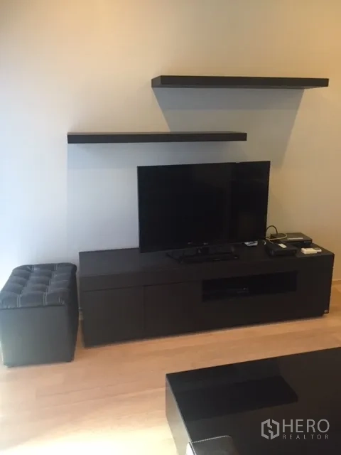 คอนโด ให้เช่าในBangkok - ผนังทีวีพร้อมชั้นลอยและตู้วางทีวี บนพื้นไม้โทนอ่อน
