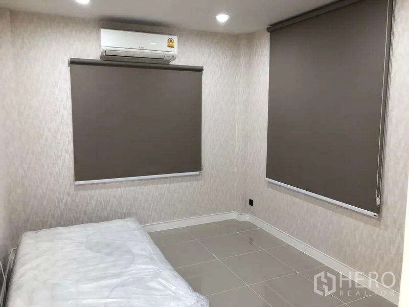 Detached House for rent in Bang Kapi, Bangkok - Cozy bedroom with tiled floors, blackout roller blinds and air conditioner.