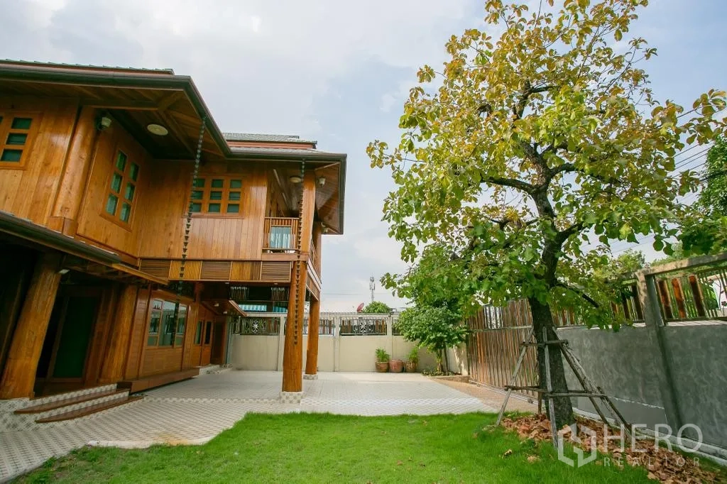 บ้านเดี่ยว for rent or sale in Huai Khwang, Bangkok - บ้านเดี่ยวไม้สองชั้น พร้อมลานปูกระเบื้อง ต้นไม้ใหญ่ และสนามหญ้าเขียว.