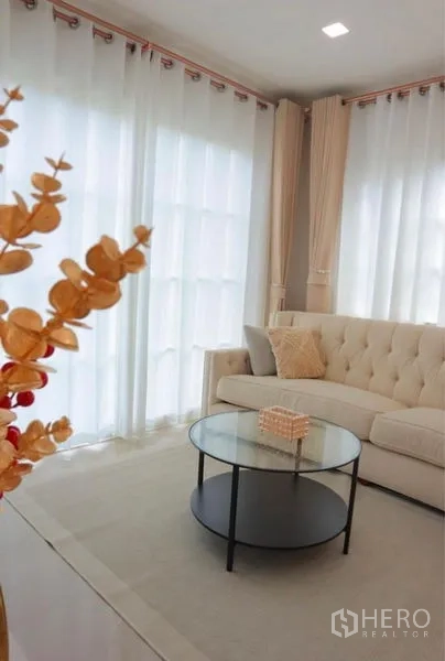 Detached House for rent in Bang Phli, Samut Prakan - Light-filled lounge corner with tufted sofa and round coffee table.