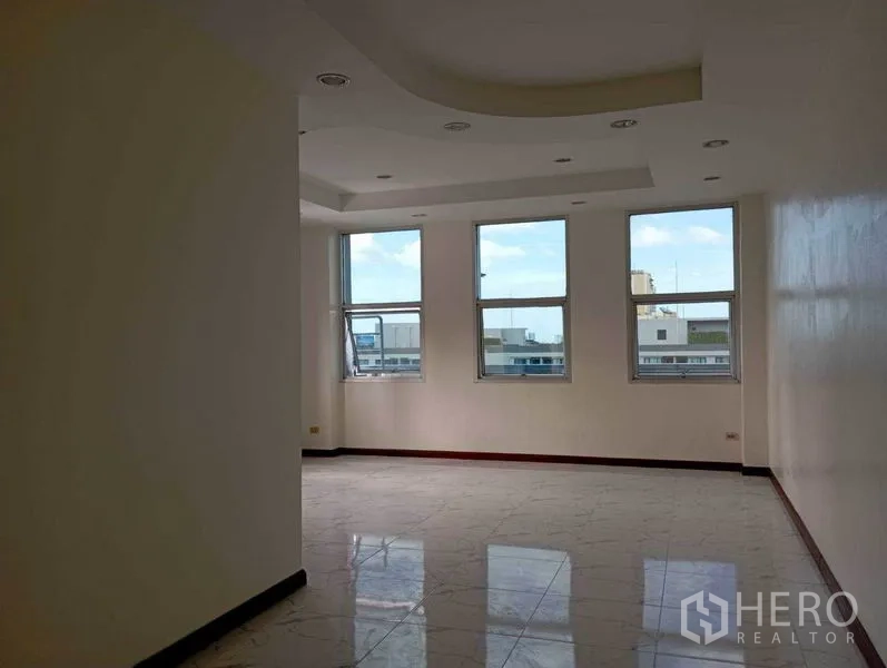 Office Space for rent in Khlong Toei, Bangkok - Open workspace with cove ceiling, recessed lights and three large windows.