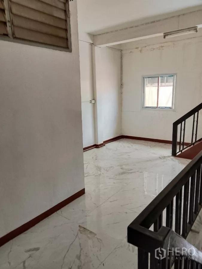 店屋 出租在Bang Rak, Bangkok - 楼梯平台明亮，仿大理石地砖与栏杆相邻。